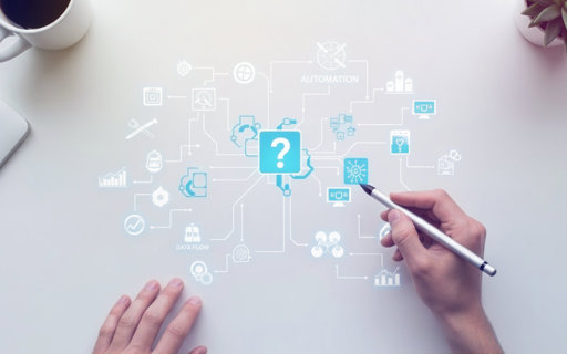 En person använder en digital penna på en vit yta där olika blå ikoner och linjer visualiserar ett nätverk för automation och dataflöde, med en central symbol som visar ett frågetecken.