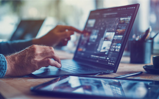 Närbild på händer som arbetar vid en laptop med digital analys på skärmen, medan en annan person pekar ut detaljer.