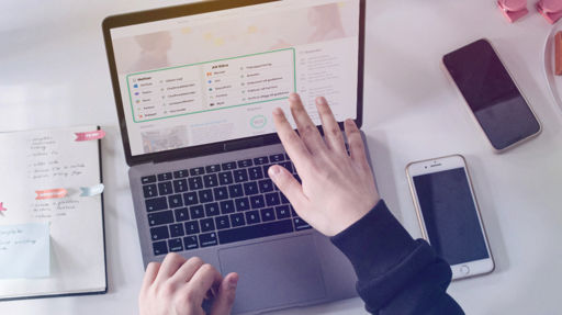 En person arbetar vid en laptop som visar en kontrollpanel med notiser och uppgifter från flera olika system.
