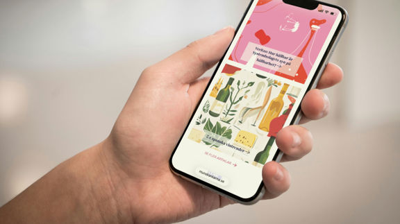 Hand håller en smartphone som visar Munskänkarnas webbsida med artiklar och illustrationer om vin och hållbarhet.